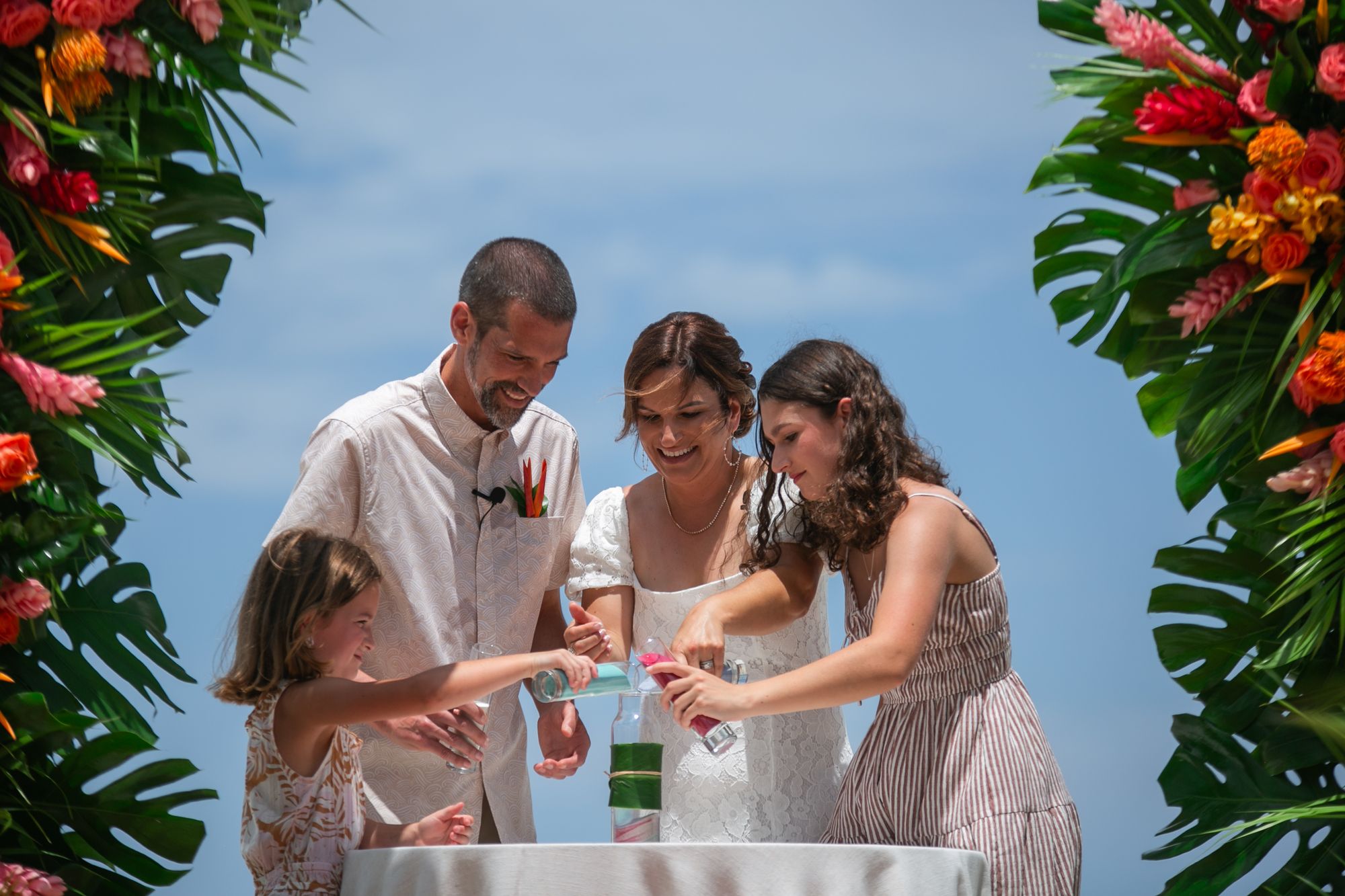 family of four pouring colored sand into a bottle at beaches negril