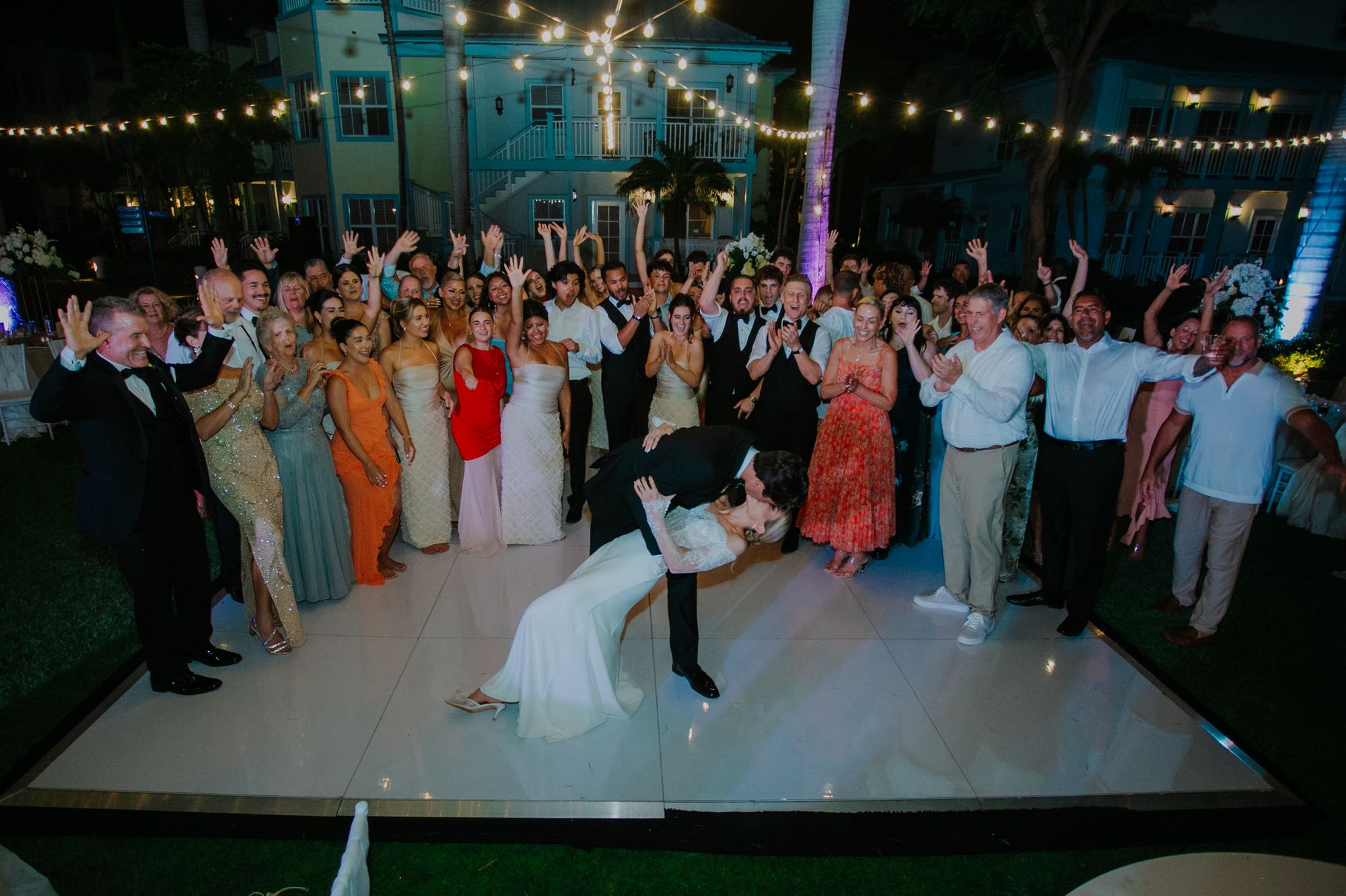 jackson and sara kissing at their wedding reception with guests cheering at beaches turks and caicos