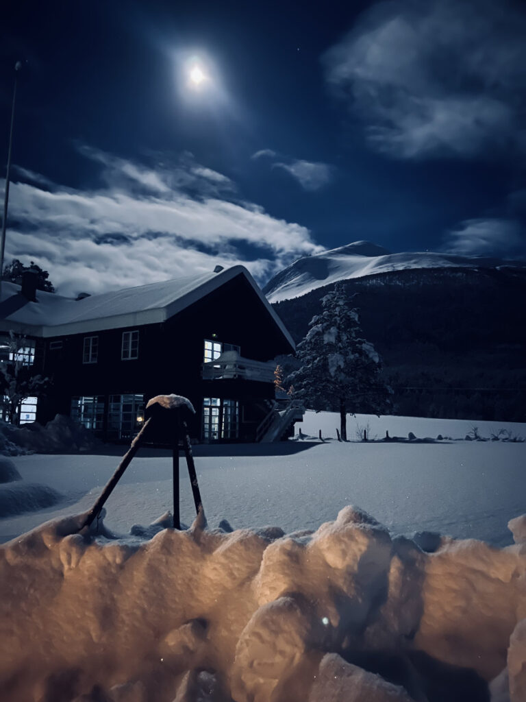 A snowy nighttime scene of Phillipshaugen Lodge in Norway