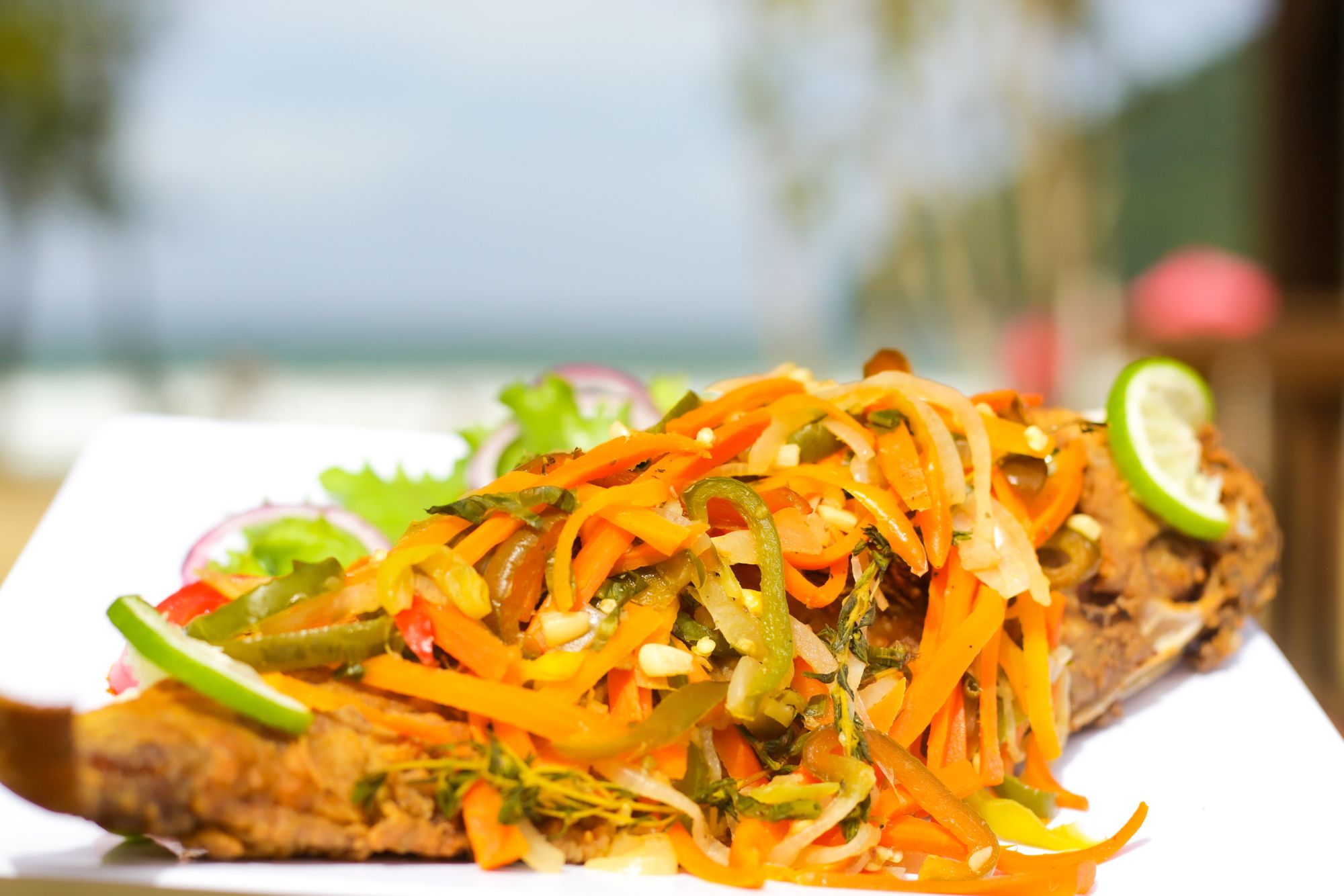 plate of fried fish with assorted veggies and lime