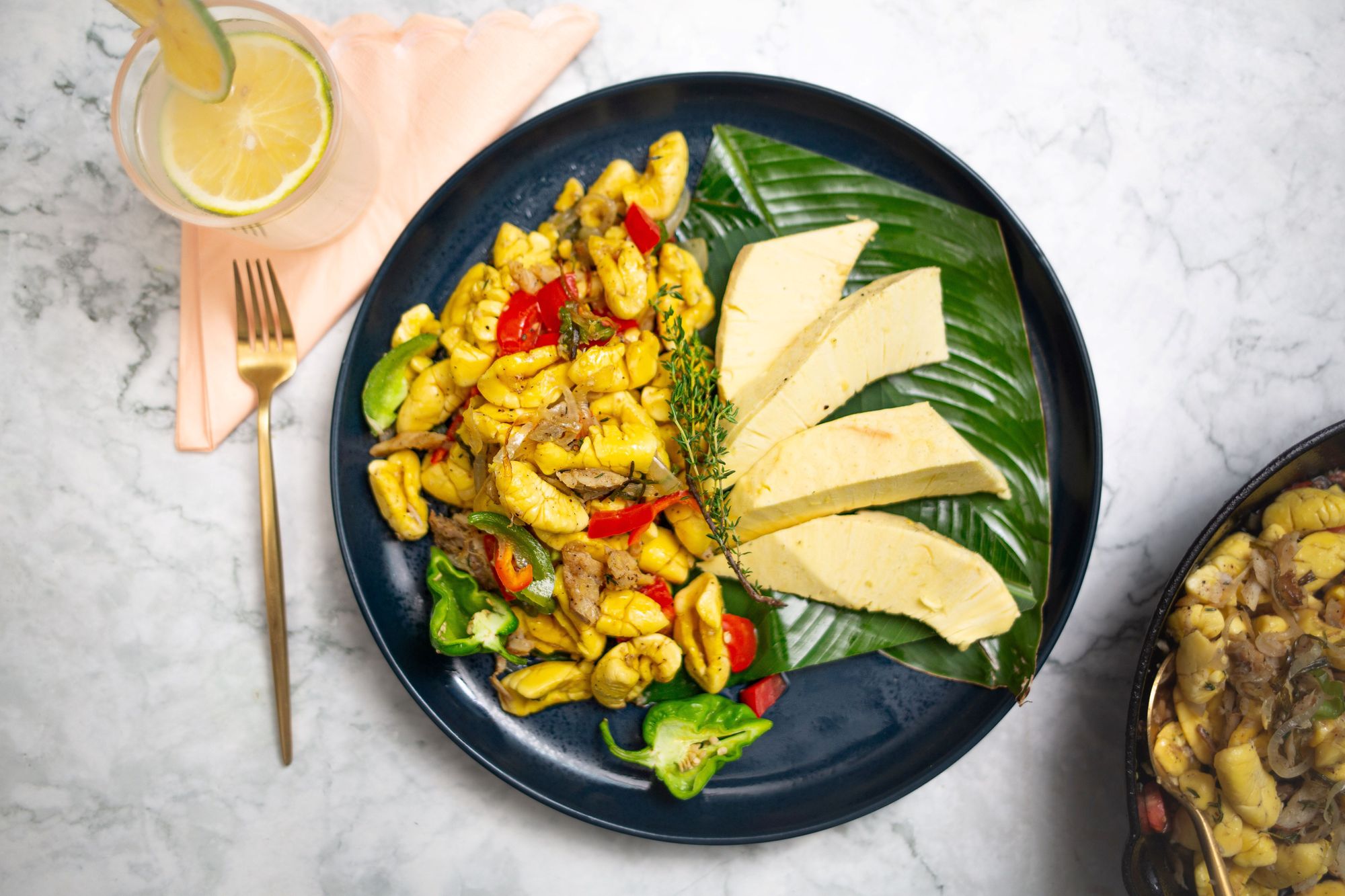 Breadfruit with ackee and saltfish served in a black plate