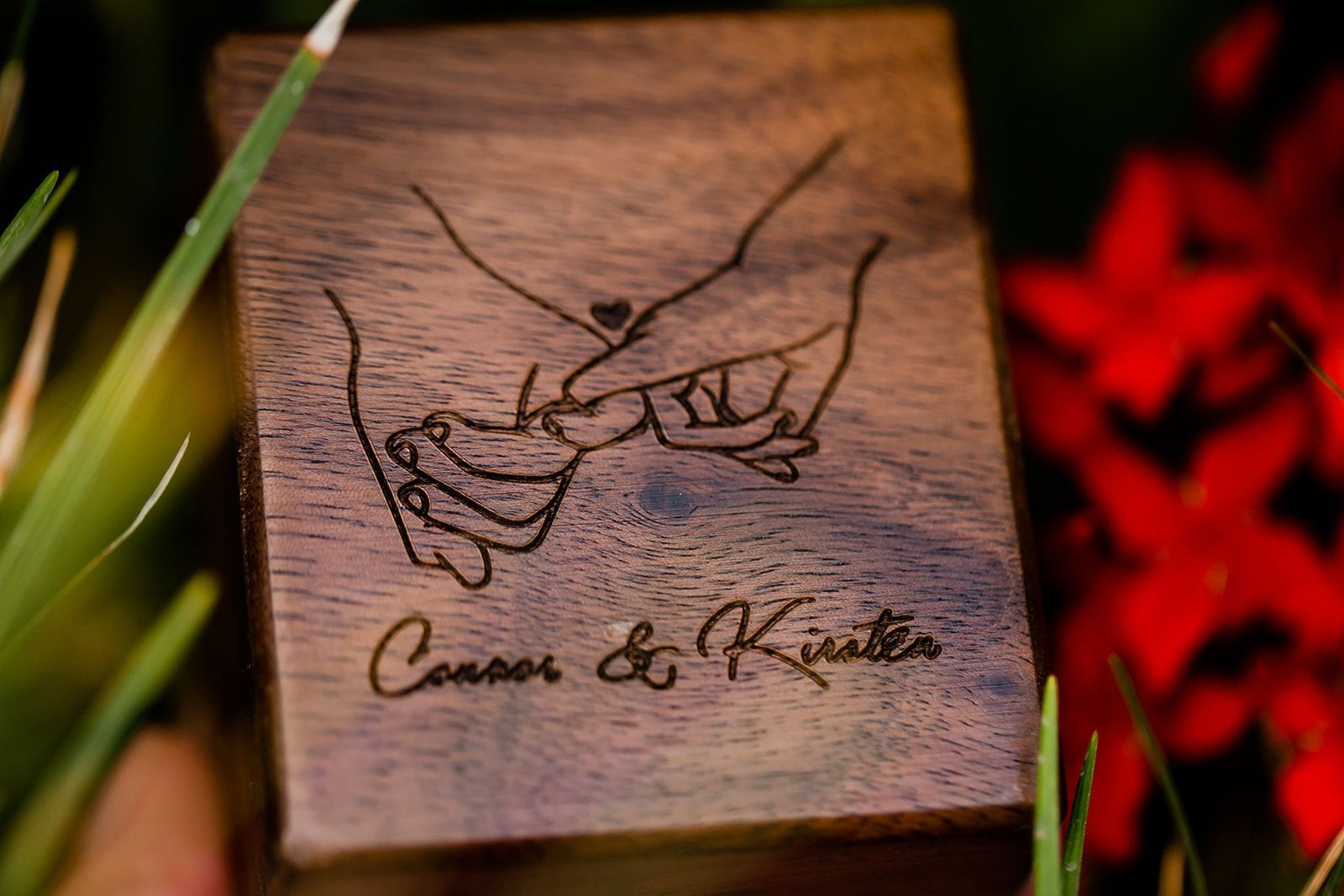 wooden box with an engraving of a pinky promise and the names conor & kirsten