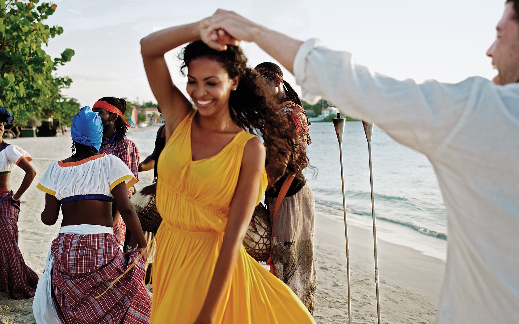 man and woman dancing on the beach together