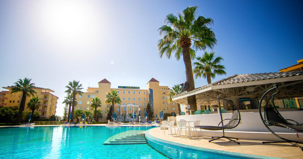 Hotel Adriatik, a 5-star hotel with a pool, palm trees in Durres, Albania.