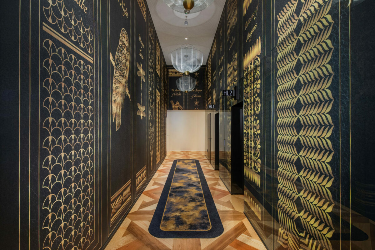 Black and gold geometric patterned walls line the hallway of the Kimpton BEM hotel